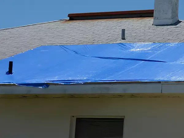 Blue tarp over damaged roof